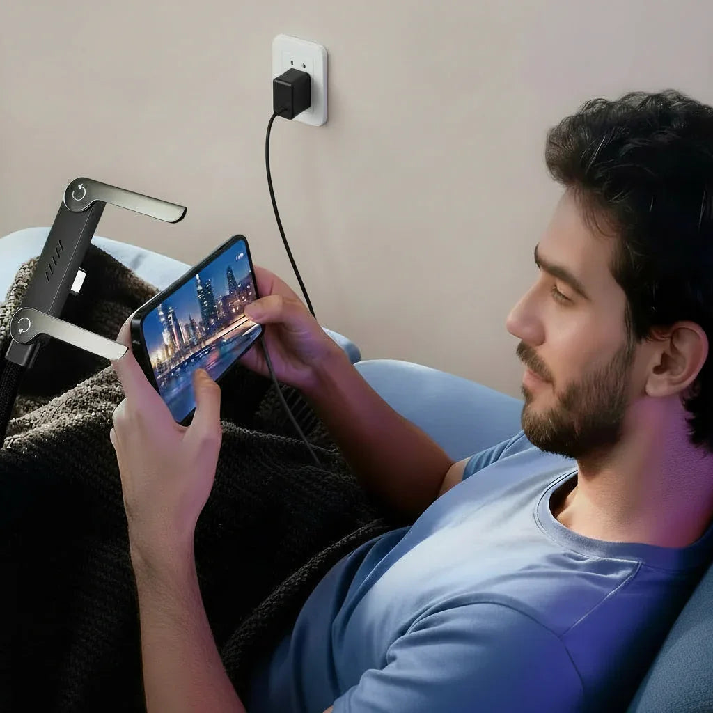 Man relaxing on sofa using adjustable phone holder and charging smartphone